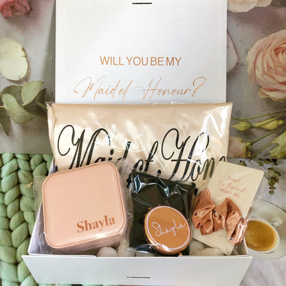 Our gift box includes personalized items like wedding robes, a compact mirror, travel jewelry box, and message scrunchies, offering a thoughtful and stylish gift for any special occasion.