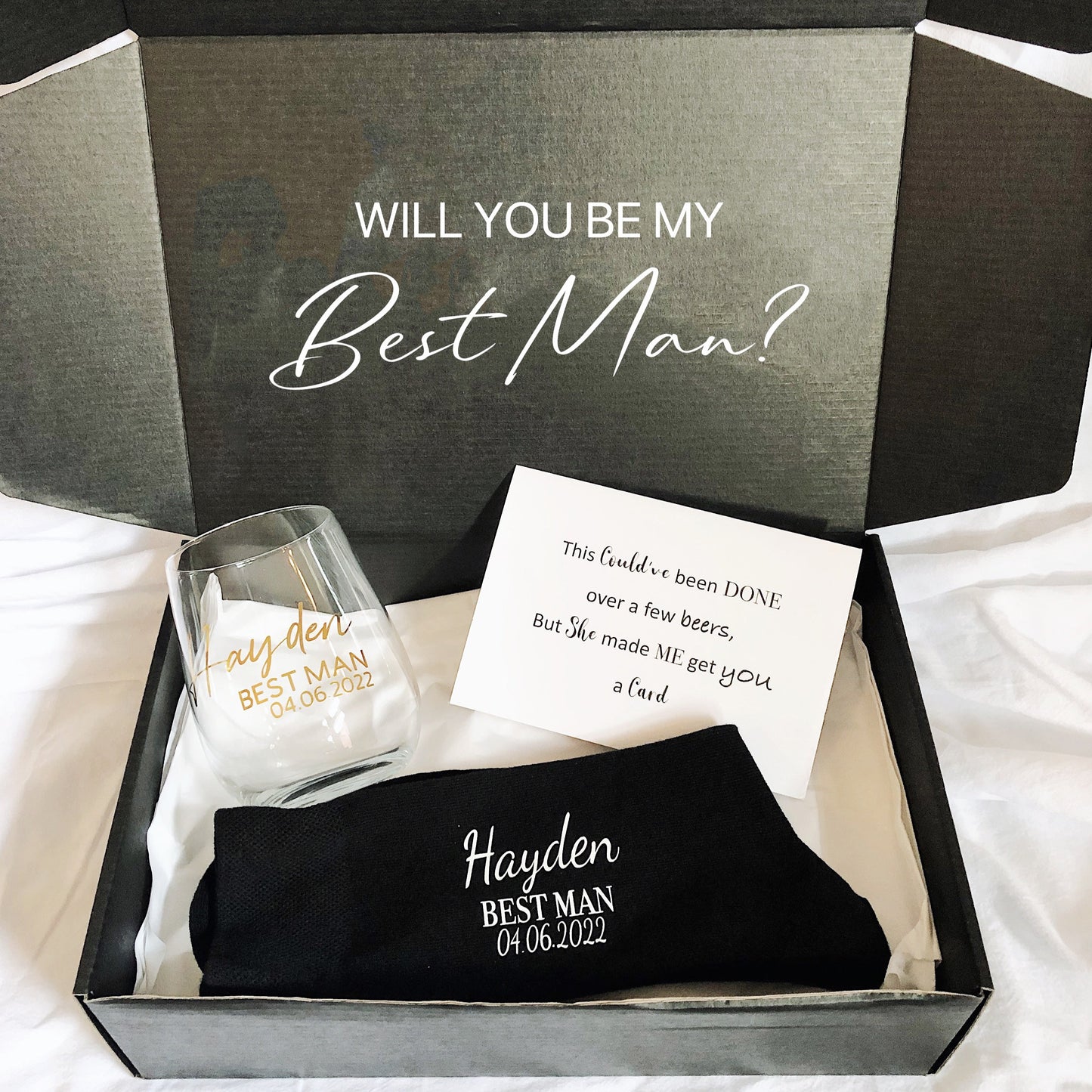 Find the perfect groomsman gift box, featuring personalized items such as glasses, socks, and a card, all elegantly packaged to make your wedding party feel special.