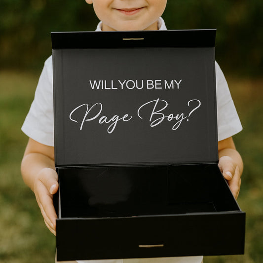 Young boy holding a black box with 'Will you be my page boy?' text.