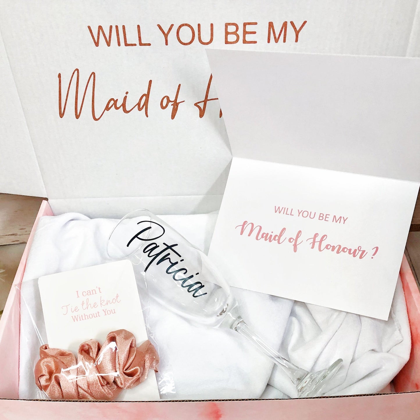 Our personalized gift box, perfect for any special occasion, includes a customized box, card, champagne flute or stemless glass, and message scrunchies, available in elegant Marble Pink or White Ribbon.